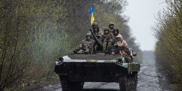 Ukrainian soldiers ride atop an armored fighting vehicle Tuesday as Russia's assault on Ukraine continues in an unknown location in eastern Ukraine.