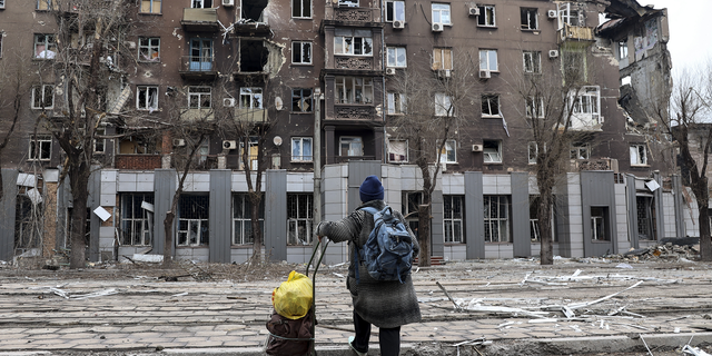 A citizen looks at a destroyed apartment building in Mariupol, Ukraine, on Saturday. 