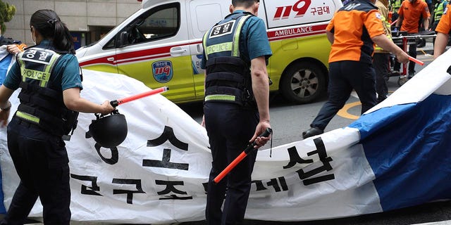 South Korean police officers and firefighters inspect the site of a fire in Daegu, South Korea, Thursday, June 9, 2022. Several people were killed and dozens injured Thursday in the blaze that spread to an office building in Daegu, South Korea.  City, local fire officials and police said.  (Park Si Jin/Yonhap via The Associated Press)