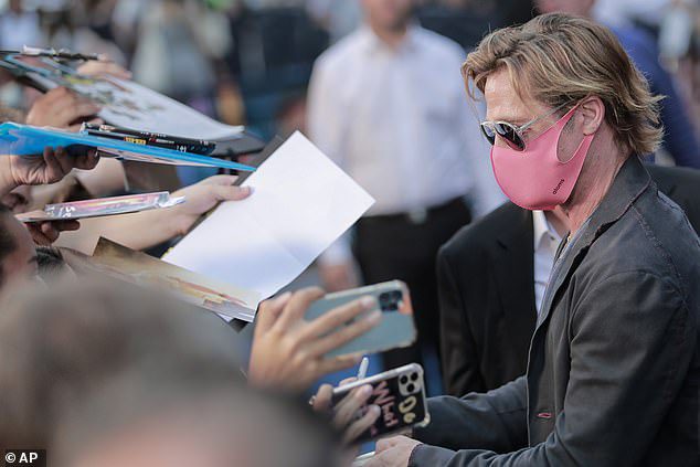 Tribute to his fans: Brad wore a pink face covering to protect himself and others from coronavirus while signing autographs for fans at the event