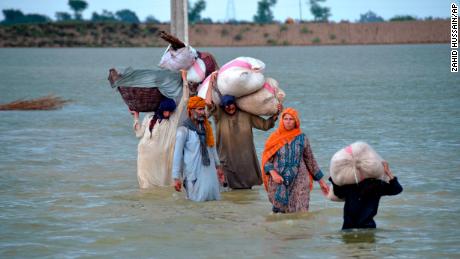 A displaced family wades in a flooded area in Jafarabad, a district of Pakistan's southwestern Balochistan province, on August 24.