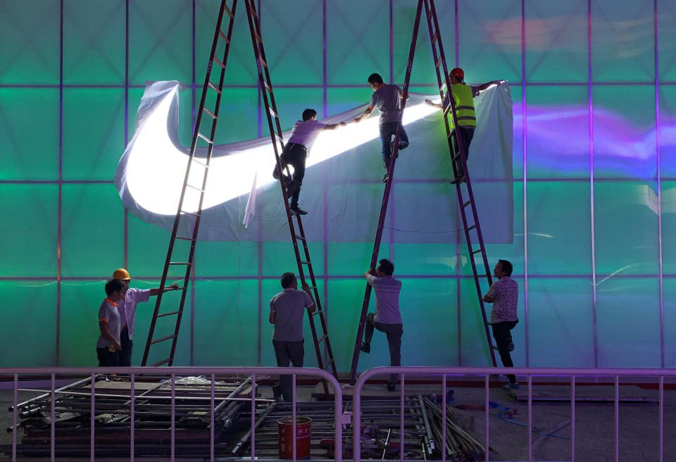 Workers install a Nike logo lamp outside the Wukesong Arena in Beijing, China, August 28, 2019. Photo taken on August 28, 2019. REUTERS / Tingshu Wang