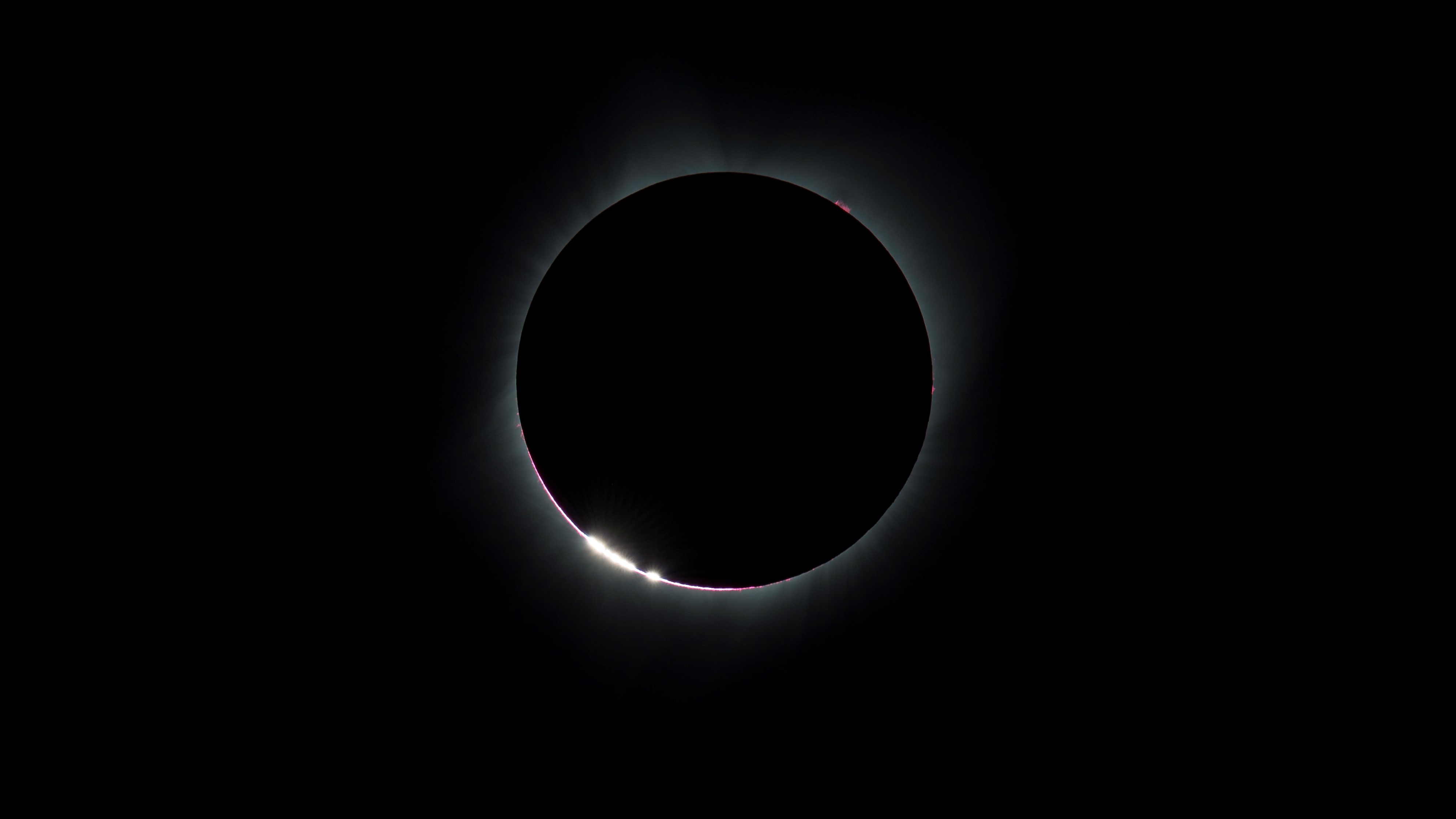 Bright grains of light are produced around the edge of a pre-total solar eclipse.