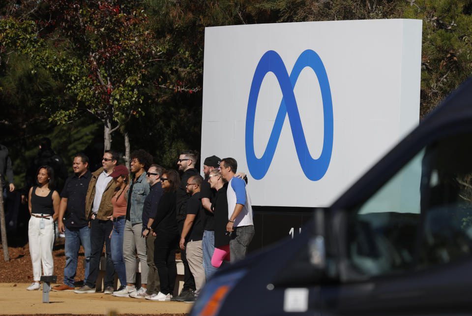 Facebook employees gather in front of a banner displaying a new logo and the name & # 39;  Meta & # 39;  In front of Facebook headquarters on October 28, 2021 in Menlo Park, California.  (Photo by Justin Sullivan/Getty Images)